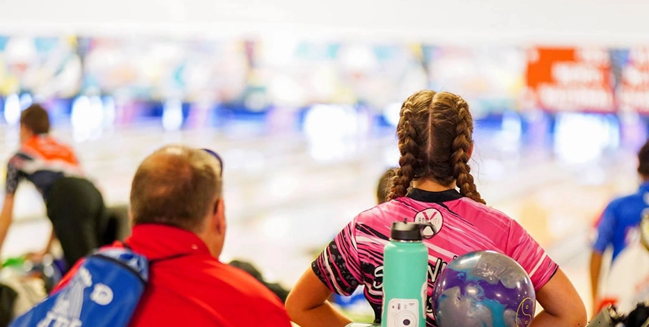 The Mount Mercy University Bowling Team practices together in a well-lit bowling alley.